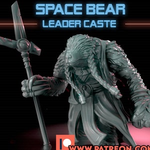 Può includere: Una statuetta grigia di un Space Bear Leader Caste, che tiene in mano un bastone con una croce in cima. La figura simile a un orso ha i capelli intrecciati e indossa un mantello. Il testo in alto recita "SPACE BEAR LEADER CASTE".