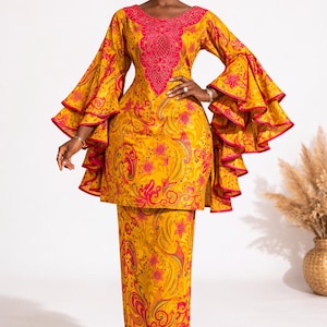 May include: A striking yellow two-piece outfit with a matching head wrap. The ensemble features a long-sleeved top with flared sleeves and a pencil skirt, both decorated with a red floral pattern. The top has a red embroidered neckline.