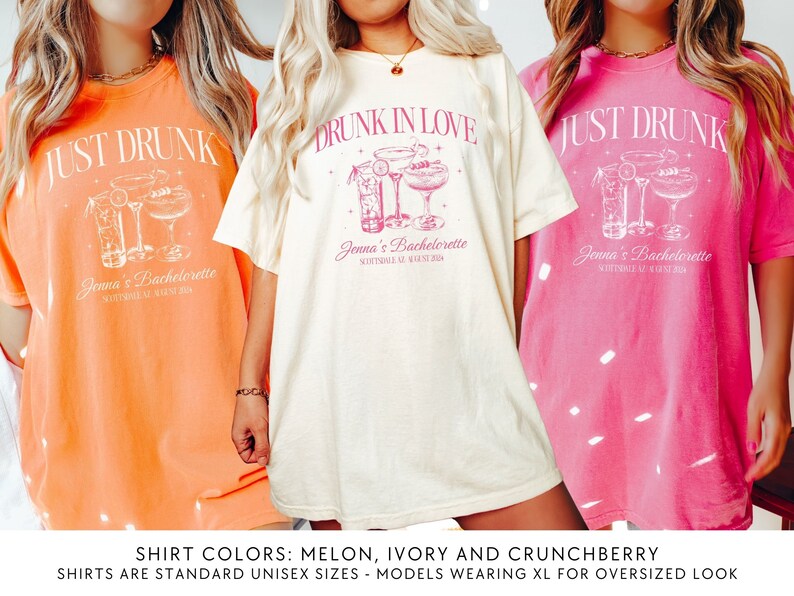 May include: Three t-shirts in different colours and designs. The first shirt is orange with the text "JUST DRUNK" and a cocktail graphic. The second shirt is ivory with the text "DRUNK IN LOVE" and a cocktail graphic. The third shirt is pink with the text "JUST DRUNK" and a cocktail graphic. All shirts have the text "Jenna's Bachelorette" and a date.