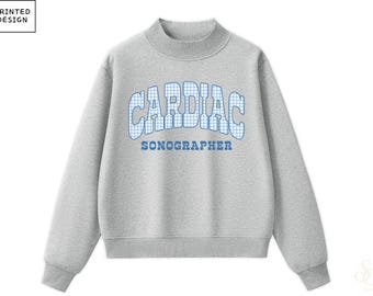 May include: A heather grey crewneck sweatshirt featuring a mock neck collar and long sleeves. The chest displays the text CARDIAC in a blue and white gingham pattern, with the word SONOGRAPHER printed in solid blue letters below it.