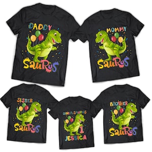 May include: Five black t-shirts featuring a dinosaur graphic and the words "Daddy", "Mommy", "Sister", "Brother", and "One-a-saurus Jessica" printed on them. The dinosaur is green and holding balloons.