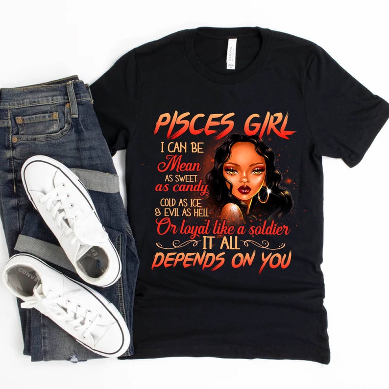 May include: Black t-shirt with a graphic of a woman with a red and orange design. The text on the shirt reads "Pisces Girl I can be Mean as sweet as candy cold as ice & evil as hell Or loyal like a soldier It all depends on you".