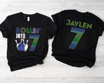 May include: Black t-shirts with a bowling theme. One shirt says "Rollin' into 7" with a bowling pin and ball graphic. The other shirt says "Jaylen" with a number 7 graphic.