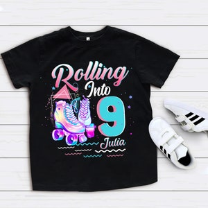 Może przedstawiać: Czarny T-shirt z grafiką rolek i tekstem "Rolling into 9 Julia".