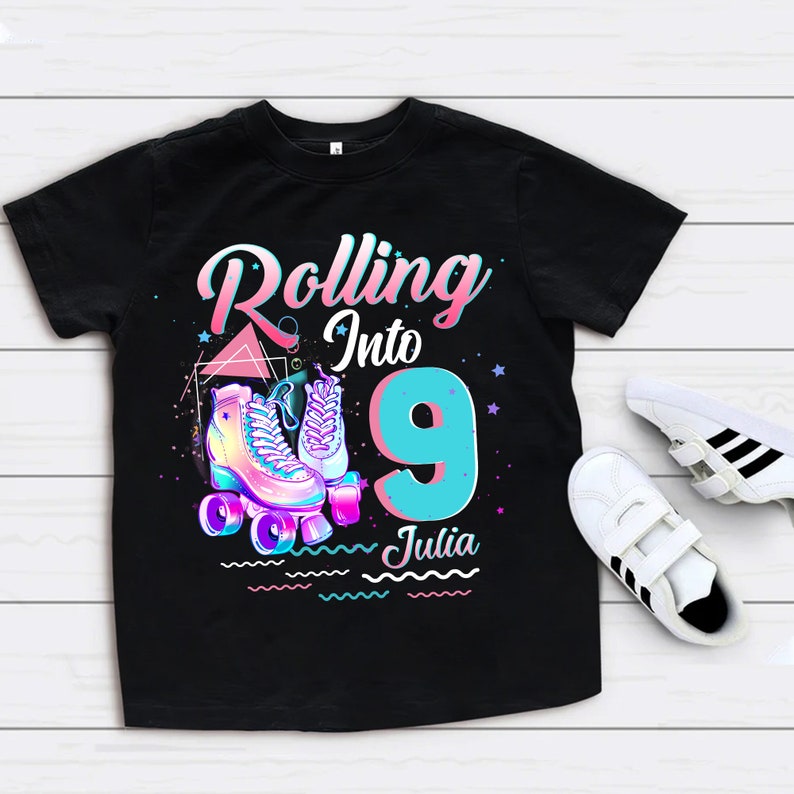 Może przedstawiać: Czarny T-shirt z grafiką rolek i tekstem "Rolling into 9 Julia".