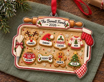 May include: A rectangular Christmas ornament shaped like a baking tray with a rolling pin handle, featuring personalised cookie-shaped decorations labelled James, Sarah, Lucas, Ava, Henry, Teddy, Grace, and Ella, with text reading The Bennett Family 2026.