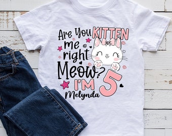 May include: White t-shirt with a pink and white kitten graphic. The text reads "Are you kitten me right Meow? I'm 5 Mellynda".