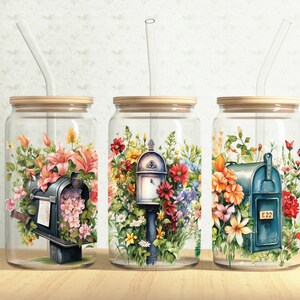 May include: Three glass jars with lids and straws, each featuring a different floral design with a mailbox. The mailboxes are painted blue and have a floral design. The jars are filled with colorful flowers and greenery.