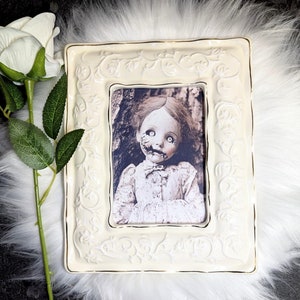 Haunted Porcelain Doll Wall Art: Gothic Macabre Decor in Ivory Frame