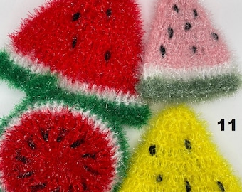 Puede incluir: Cuatro paños de cocina de ganchillo en forma de sandía en rojo, rosa, amarillo y verde. Los paños de cocina están numerados del 8 al 11.