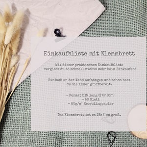 Puede incluir: Una lista de la compra en un portapapeles con el texto Einkaufsliste mit Klemmbrett, Mit dieser praktischen Einkaufsliste vergisst du so schnell nichts mehr beim Einkaufen!, Einfach an der Wand aufh&auml;ngen und schon hast du sie immer griffbereit., Format DIN lang (21x10cm), 50 Blatt, 80g/m&sup2; Recyclingpapier, Das Klemmbrett ist ca 28x11cm gro&szlig;.