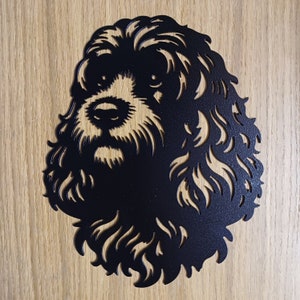 May include: Black metal silhouette of a dog's head with curly fur. The dog's face is visible with a detailed nose and mouth.