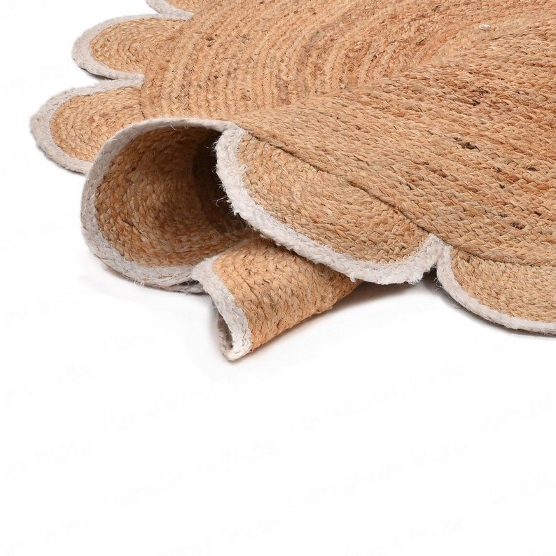 Pode incluir: Um tapete redondo de fibra natural com uma borda festonada. O tapete &eacute; feito de juta e tem uma bainha branca.