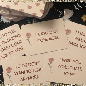 May include: A set of pink affirmation cards with rose illustrations and text. The cards feature phrases like "I need to feel more confident before I come back to you" and "I know we will come back together".