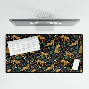 May include: Black desk mat with a repeating pattern of gold leopards, green leaves, and pink flowers. A white keyboard and mouse are on the mat.