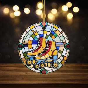 May include: Round ornament featuring a stained-glass design with yellow roller skates. The skates have red laces and are set against a backdrop of colorful glass panes. A gold string is attached for hanging.