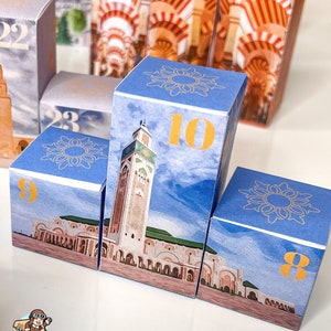 May include: A set of blue and gold cardboard boxes with numbers 8, 9, 10, 22, and 23. Each box features a different image of a mosque with a blue sky background.