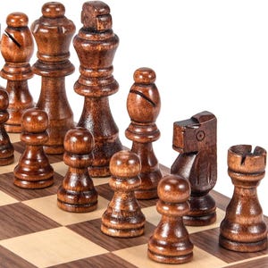 May include: A close-up of a wooden chess set with dark brown pieces on a checkered board. The pieces include pawns, rooks, knights, bishops, and a king. The chess pieces are arranged on a brown and tan checkered board.
