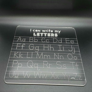 May include: A clear plastic dry-erase board with the text "I can write my LETTERS" at the top. The alphabet is written in rows with dotted lines for tracing.
