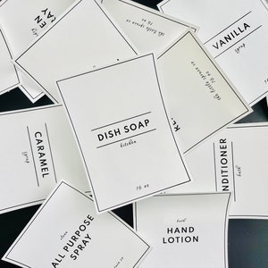 Peut inclure: Un ensemble de 10 étiquettes blanches avec du texte noir pour divers produits ménagers. Les étiquettes comprennent "Savon à vaisselle", "Spray tout usage", "Lotion pour les mains", "Après-shampoing", "Sirop de vanille", "Sirop de caramel" et "Savon".