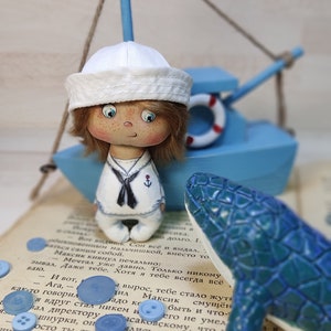 Sailor captain miniature doll in a box. Small doll made of handmade fabric. doll in bed