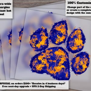 May include: A stack of prints featuring a blue and gold paw print design. The prints have text that reads "Extra-wide cut margins Instant hot peel" and "100% Customizable! Change part of the design, or create a completely new design with the same style!"