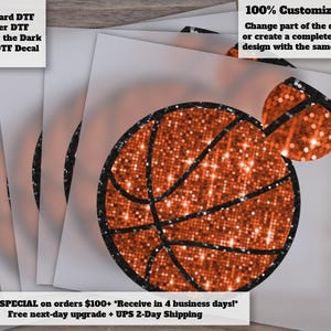 May include: A basketball-shaped decal featuring a vibrant orange glitter texture with black outlines. The design includes a circular basketball main body and a smaller circular accent piece attached at the top right, both displaying a sparkling finish.