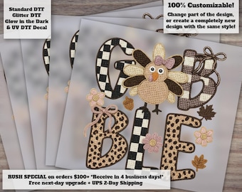 May include: A DTF decal design featuring the word GOBBLE with a turkey illustration replacing the letter O. The letters feature black and white checkered and leopard print patterns. The design includes pink flowers, a small acorn, and brown leaves.