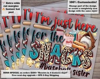 May include: A stack of baseball-themed sublimation transfers. The design features the text "I'm just here for the snacks" with baseball imagery, popcorn, peanuts, a hot dog, and a baseball glove. The text "#baseball sister" is also included.