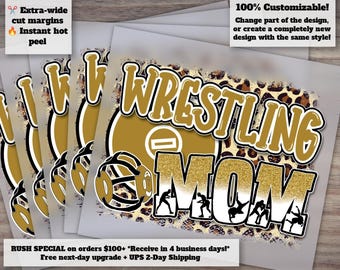 May include: A heat transfer design featuring the word WRESTLING in gold with a black outline above the word MOM in gold glitter. The design includes a gold wrestling mat graphic, a black wrestling headgear icon, and a leopard print background.