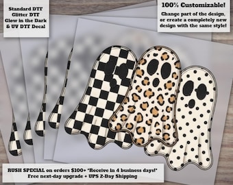 May include: A set of three ghost-shaped decals featuring distinct patterns: one with a black and white checkerboard print, one with a tan and black leopard print, and one with a white and black polka dot print. Each ghost has two black oval eyes.