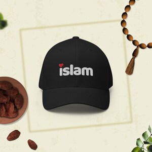 Könnte beinhalten: Schwarze Baseballkappe mit dem Wort "islam" in Weiß gestickt, mit einem roten Herzsymbol. Die Kappe hat ein klassisches Sechs-Panel-Design.