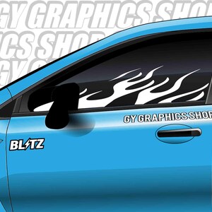 Puede incluir: Una puerta de coche azul claro con una calcomanía de llama blanca en la ventana. El texto "GY GRAPHICS SHOP" está impreso en la puerta, y la palabra "BLITZ" está impresa en el coche.