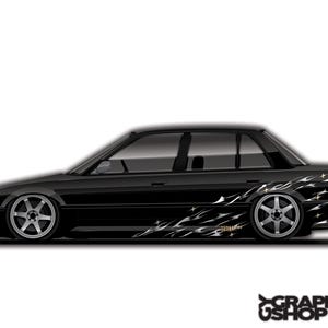 Puede incluir: Sedán negro con llantas plateadas y un diseño de llamas en el lateral. El coche tiene cristales tintados y un perfil bajo. La imagen incluye el texto "GRAPHICS USHOP".