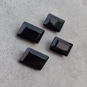 May include: Four black rectangular gemstones with a polished finish.