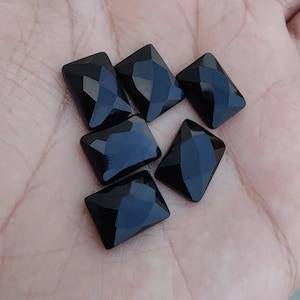 Può includere: Sei cabochon di pietra preziosa nera con taglio sfaccettato. Le pietre sono di forma quadrata e hanno una finitura lucida.