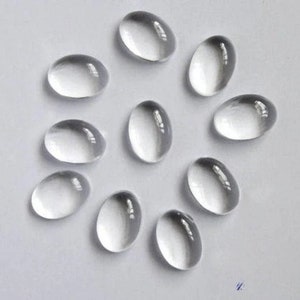 Könnte beinhalten: Eine Sammlung von 11 klaren, ovalen Glascabochons. Die Cabochons sind glatt und poliert.