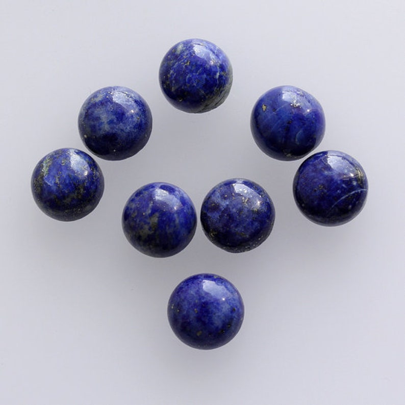 May include: Eight round, blue lapis lazuli cabochons with gold flecks. The cabochons are smooth and polished.