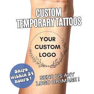May include: A temporary tattoo on an arm with the text "CUSTOM TEMPORARY TATTOOS". The tattoo features a circular design with the words "YOUR CUSTOM LOGO" inside a floral wreath. Additional text reads "SEND US ANY LOGO OR IMAGE!"