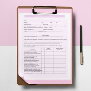 May include: A clipboard with a pink form titled "Client Health History: Microcurrent." The form includes sections for personal information, health history, and a questionnaire about potential contraindications. A pen rests on the right side.