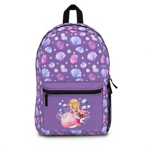 以下が含まれることがあります： 紫色のバックパック。貝殻模様と、ピンクのクジラに乗る人魚が描かれたフロントポケットが付いています。バックパックには黒いハンドルとジッパーが付いています。貝殻模様には、ピンク、青、白の貝殻が含まれています。