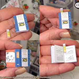 May include: A miniature cookbook titled "Mastering the Art of French Cooking" with a blue cover and white text. The book is open to a page with a recipe and illustrations. The book is 1:12 scale.