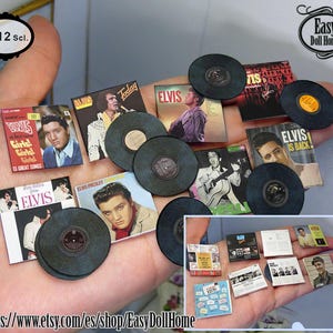 May include: A collection of miniature vinyl records featuring Elvis Presley album covers. The records are displayed on a hand, with the text "Easy Doll Home" visible in the background.