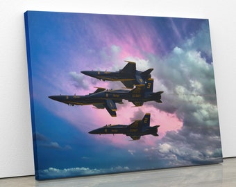 Puede incluir: Cuatro aviones de combate azules y amarillos vuelan en formación sobre un fondo de nubes rosadas y azules. Los aviones forman parte de los Blue Angels, el escuadrón de demostración de vuelo de la Marina de los Estados Unidos.