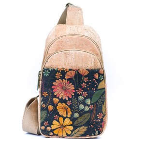 May include: A tan cork sling backpack featuring a front pocket with a dark navy blue background and a vibrant floral print. The bag includes a beige adjustable strap, a top zipper closure, and a secondary zipper for the main compartment.