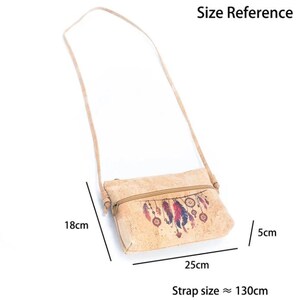 May include: A light brown cork crossbody bag with a zipper closure and a long strap. The bag features a dreamcatcher design with red, blue, and purple feathers. The bag is 25cm wide, 18cm high, and 5cm deep, with a strap approximately 130cm long.