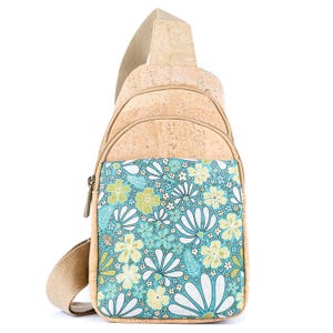 May include: A sling backpack crafted from light tan cork material featuring a front pocket with a vibrant teal, white, and pale yellow floral pattern. The bag includes a beige adjustable strap, a top zipper closure, and a secondary front zipper.