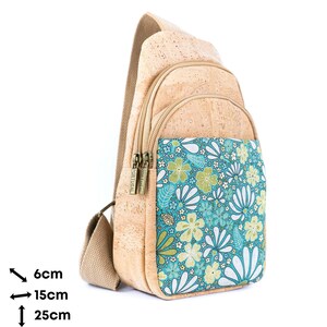 May include: A tan cork sling backpack with a beige fabric strap and two zippered compartments. The front pocket features a teal, green, and white floral pattern. The bag measures 6 inches deep, 15 inches wide, and 25 inches tall as indicated.