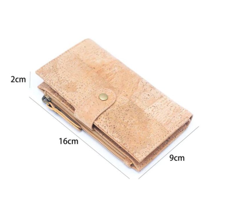 May include: A light brown cork wallet with two zippers and a button closure. The wallet measures 9 inches by 16 inches by 2 inches.