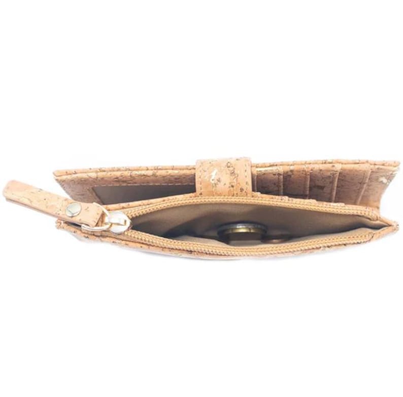 May include: A light brown cork wallet with a zippered coin pocket. The wallet is open and a coin is visible inside the pocket.